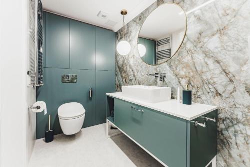 a bathroom with a sink and a mirror at Apartament SPA Lublin Centrum in Lublin
