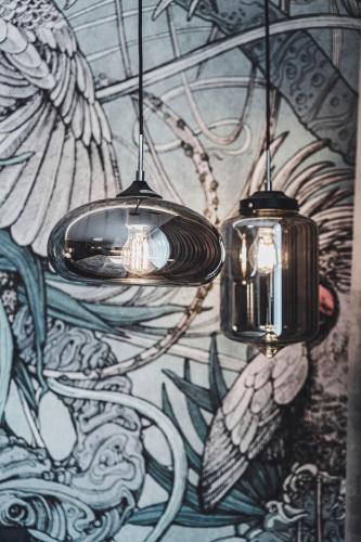 two lights hanging from a wall with a mural at Apartament SPA Lublin Centrum in Lublin