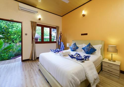 a bedroom with a large white bed and a window at Sea View Villa Ukulhas in Ukulhas