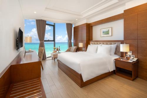 a hotel room with a bed and a television at Paris Deli Danang Beach Hotel in Danang