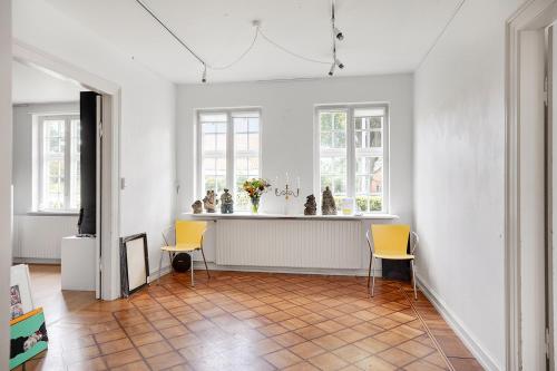 a room with two chairs and a counter with windows at Korinth Bed & Breakfast in Fåborg