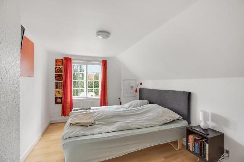 a white bedroom with a bed and a window at Korinth Bed & Breakfast in Faaborg