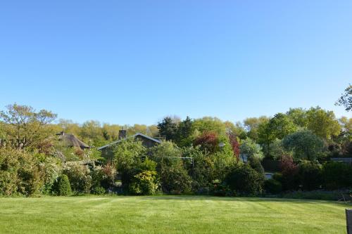 a yard with green grass and trees in the background at Villa O'Soleil in De Panne