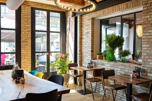 a restaurant with tables and chairs and windows at Hotel Markt23 in Sneek