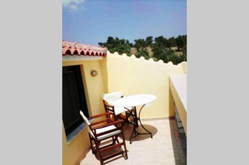 a patio with a table and chairs on a balcony at Tranquil Haven with Private Pool in Trýgonas