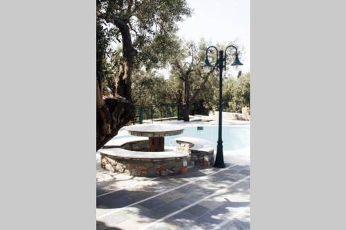 a picnic table and bench next to a pool at Tranquil Haven with Private Pool in Trýgonas