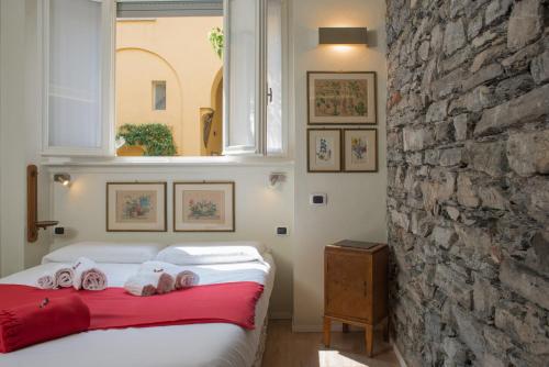 1 dormitorio con 1 cama con toallas en La Corte di Zizi, en Cernobbio