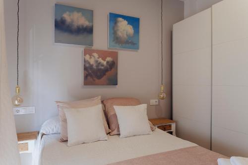 a bedroom with a bed with clouds on the wall at El Almezo in Almodóvar del Río