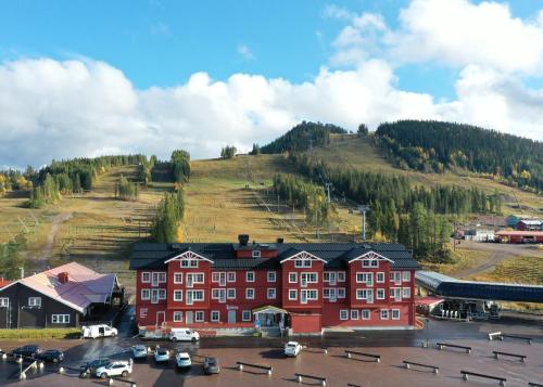 a large red building with a hill in the background at Kläppen Ski Resort in Transtrand