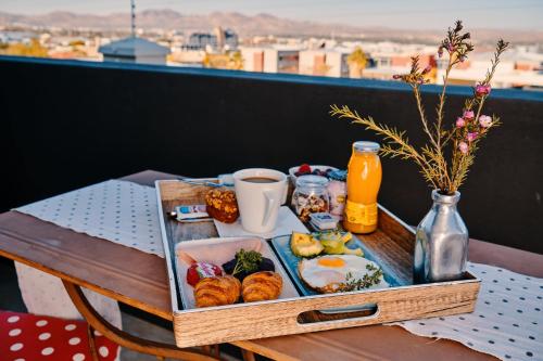 a tray of breakfast food on a table on a balcony at Haus Schwerinsburg Guest House in Windhoek
