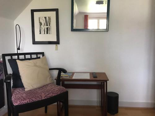 a room with a chair and a table and a mirror at Korinth Bed & Breakfast in Fåborg