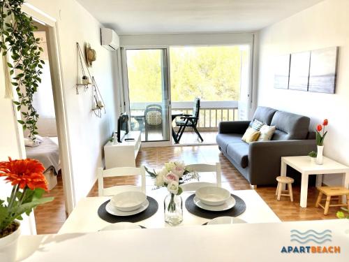 ein Wohnzimmer mit einer Couch und einem Tisch in der Unterkunft APARTBEACH CYE 6 CLIMATIZADO y JUNTO PLAYA in Salou