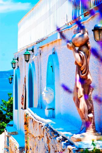 a statue of a woman on the side of a building at Villa Agnanti Boutique in Grammatiko