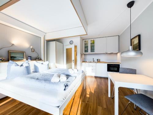 a bedroom with a white bed and a kitchen at AlpenTraum in Garmisch-Partenkirchen