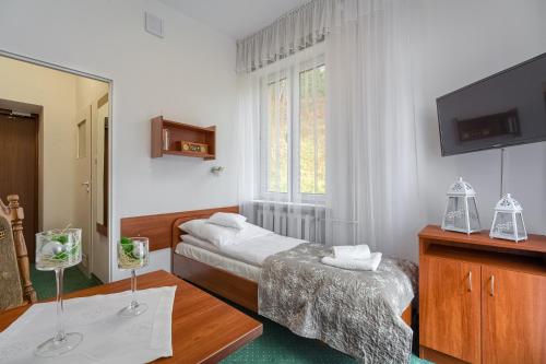 クリニツァ・ズドルイにあるDom Wczasowy Zdrowieのベッド2台とテレビが備わるホテルルームです。
