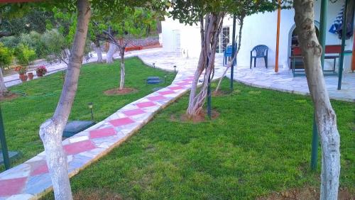 a path in a park with trees in the grass at Villa Agnanti Boutique in Grammatiko