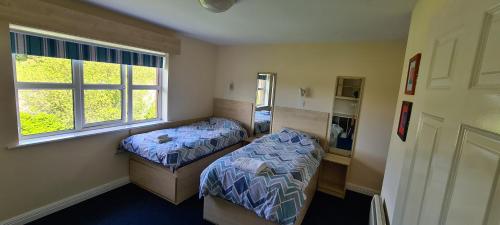 a bedroom with two beds and a window at Yeats Village in Sligo
