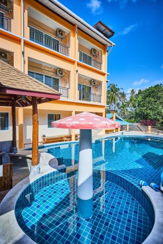 a swimming pool with an umbrella and a hotel at Coco Palm Hotel Koh tao in Koh Tao