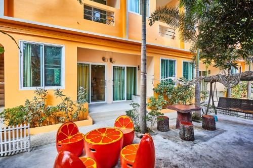 a group of orange chairs in front of a building at Coco Palm Hotel Koh tao in Koh Tao