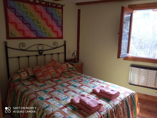 a bedroom with a bed with two pink towels on it at Molino De Pradillo in Pradillo