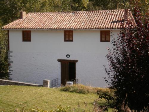 a white house with a door in the middle of a field at Molino De Pradillo in Pradillo
