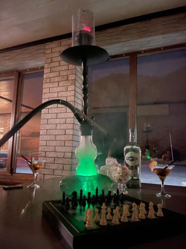 a table with a chess board and a lamp and a bottle at Царська гора in Mizhhirʼʼya