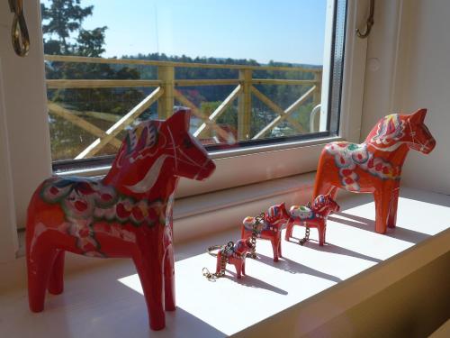 three red plastic horses on a window sill at Riddarhuset in Ljungskile