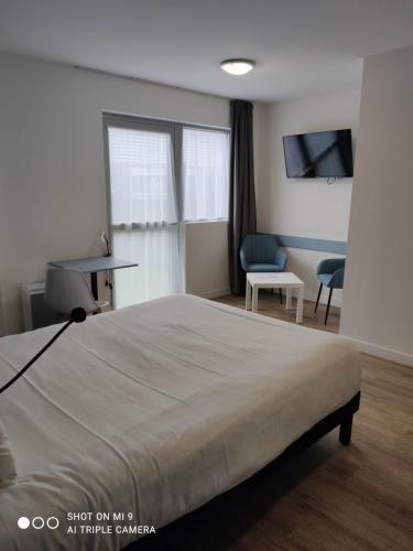 a bedroom with a bed and a desk and a chair at Atao Residence- Rennes Sud in Vern-sur-Seiche