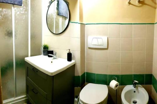 een badkamer met een toilet, een wastafel en een spiegel bij tra Miracoli e Cavalieri in Pisa