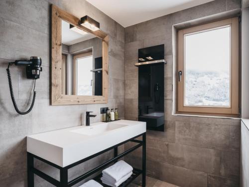 a bathroom with a sink and a mirror at VAYA Zillertal inklusive Gästekarte Erste Ferienregion Zillertal in Aschau