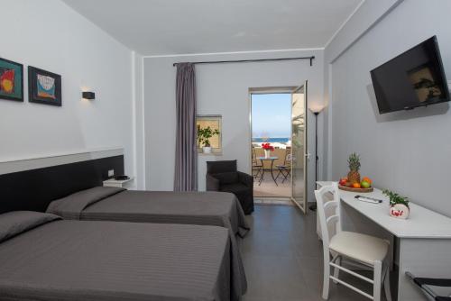 Pokój hotelowy z łóżkiem, biurkiem i stołem w obiekcie Hotel Hopps w mieście Mazara del Vallo