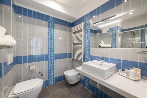 a blue and white bathroom with a toilet and a sink at Amalfi smart Rooms & Apartments - Ideale per Ragazzi in Riccione
