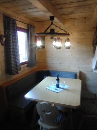 a dining room with a table with a bottle of wine at Troadkasten Seinerzeit in Aich