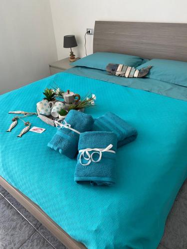 a bed with blue towels and scissors on it at APPARTAMENTI TRA CIELO E MARE in Piombino