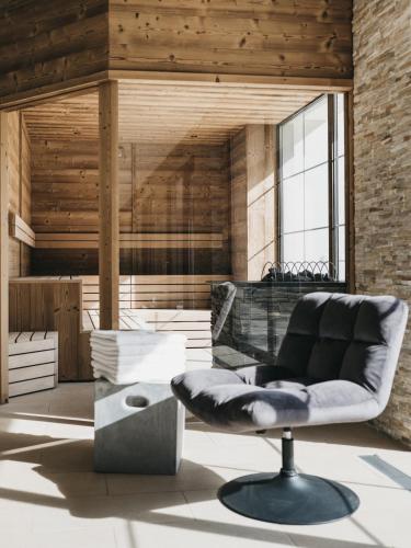 a living room with a chair and a table at VAYA Zillertal inklusive Gästekarte Erste Ferienregion Zillertal in Aschau