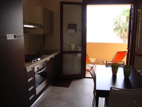 cocina con mesa, fogones y ventana en Virgilio Apartment, en Trapani
