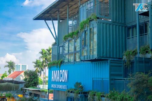 un bâtiment bleu avec un panneau sur lequel figure un panneau dans l'établissement Amacon Hotel & Coffee, à Buôn Kô Sir