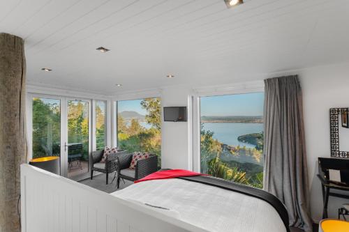 a bedroom with a bed and a view of the water at Acacia Cliffs Lodge in Taupo