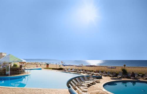 un complejo con 2 piscinas y sillas y una playa en Hotel Elitsa, en Albena