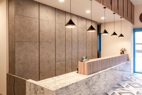 a lobby with a marble counter and pendant lights at San Chiao Hotel in Daxi
