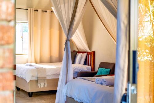 a bedroom with two beds and a window at Dzimbahwe Guest Lodge in Victoria Falls