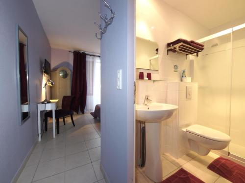 uma casa de banho com um WC branco e um lavatório. em Les chambres d'hôtes au bon accueil em Limeuil