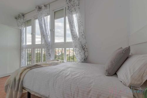a bedroom with a bed and a large window at Tres dormitorios ,vistas al mar , junto a la playa in Punta Umbría