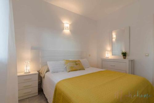 a bedroom with a large bed with two night stands at Tres dormitorios ,vistas al mar , junto a la playa in Punta Umbría