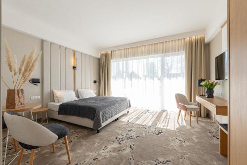 Un dormitorio con una cama y una ventana grande. en Imperiall Resort & MediSpa, en Ustronie Morskie