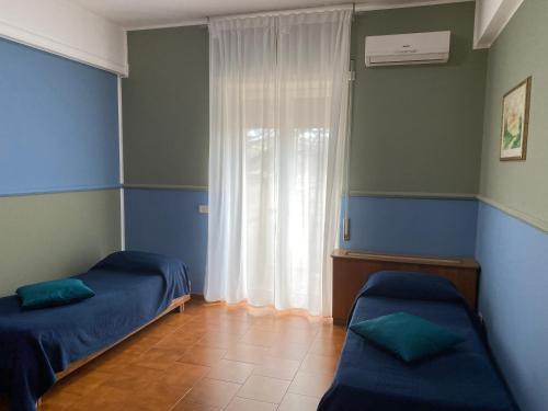a room with two beds and a window at Residence Hotel Valery in Monterotondo