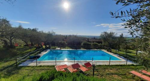 a swimming pool with a group of chairs around it at LEONÄRDO Guests House in Panicale
