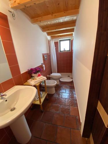a bathroom with two toilets and a sink at Orecchie di Lepre in Syracuse