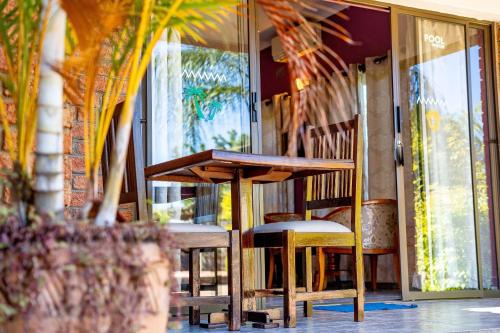 a table and chairs in front of a window at Dzimbahwe Guest Lodge in Victoria Falls