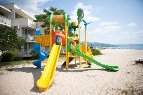 un parque infantil en la playa junto a un edificio en Hotel Mura en Albena